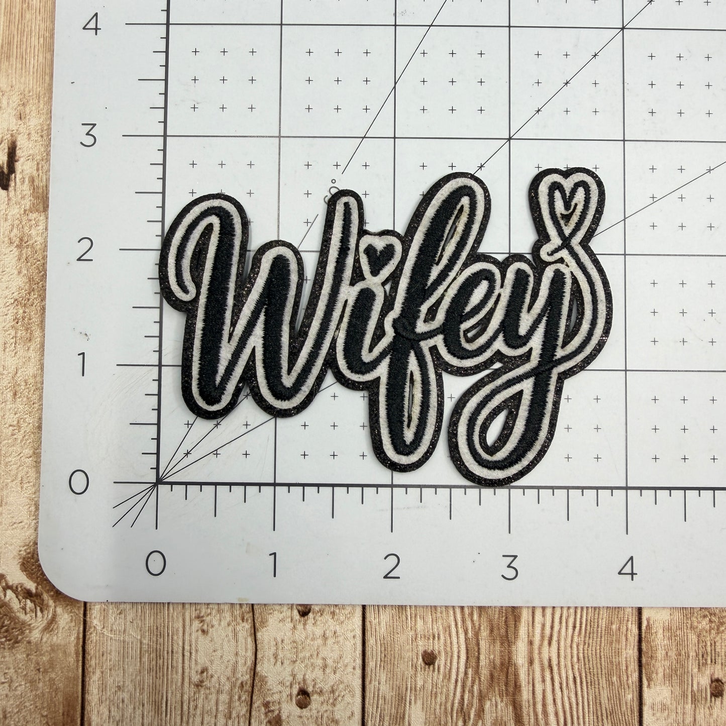 Decorative patch with 'Wifey' text on a cutting mat