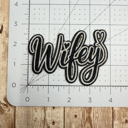 Decorative patch with 'Wifey' text on a cutting mat